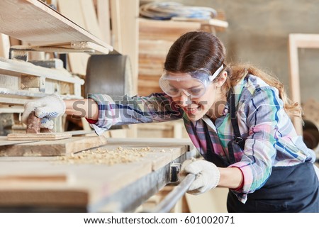Woman as joiner grinding wood Royalty-Free Stock Photo #601002071