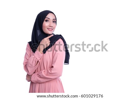 A pretty Muslim woman wearing hijab use her hands sign towards show an empty space beside her, isolated on white background Royalty-Free Stock Photo #601029176