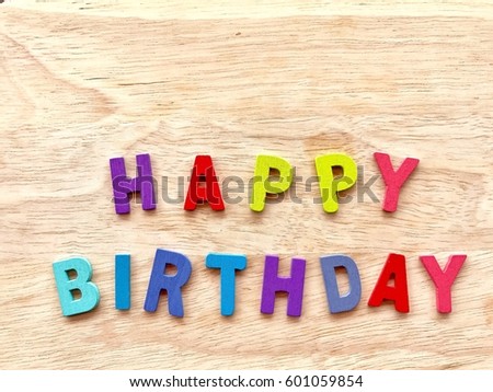 Word HAPPY BIRTHDAY colorful wooden alphabet letters set on wood board background , selective focus