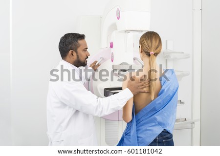 Doctor Standing Assisting Patient Undergoing Mammogram X-ray Tes Royalty-Free Stock Photo #601181042