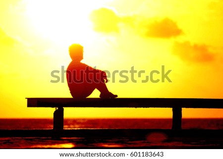 Silhouette woman relaxing with sun flare effect on sunrise time at beach.