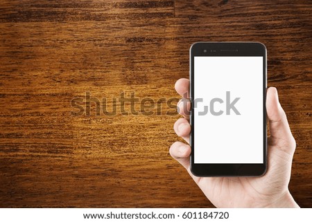 hand using smartphone with blank screen on close-up old wooden texture with dark vignette, copyspace for text