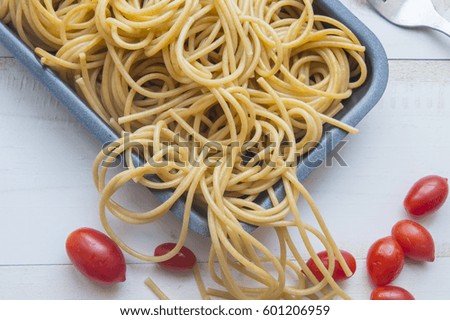 Organic whole wheat bunch of raw italian spaghetti pasta on a white table background, selective focus.