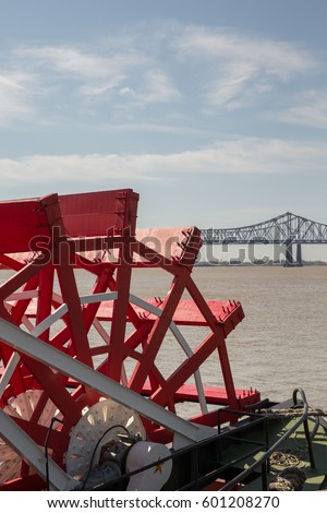 Looking at a red paddlewheel and back at the farthest downstream bridge on the Mississippi River.  Copy space in upper part of frame.