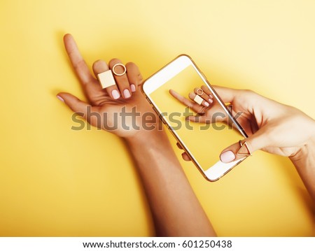 womans hand taking picture of her new manicure with fashion jewellery on her phone, girls stuff concept