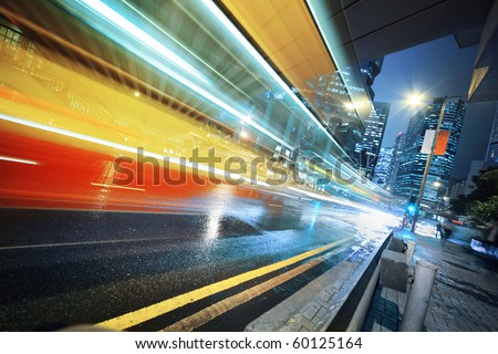 Long exposure shot of blurred bus speeding through night street.
