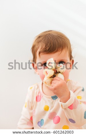 Portrait of beautiful little girl smelling flowers isolated on white background with copy space