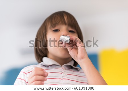 young happy boy having fun and blowing a noisemaker