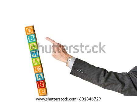 Senior male politician hand pushing over  a stack of childs blocks spelling Obamacare in Congress isolated against white background