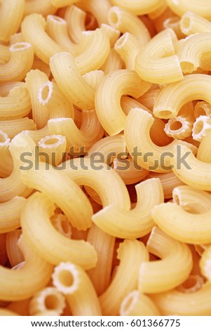 Macaroni dry pasta background concept. Pasta texture for background uses. Swirled pasta pattern. Food photography in studio.
