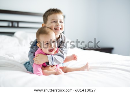baby and his brother on bed Royalty-Free Stock Photo #601418027