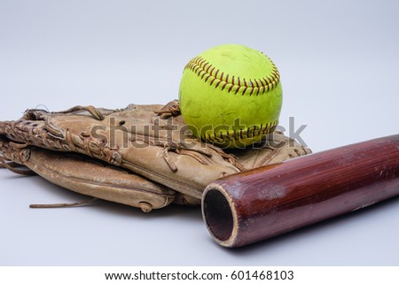 Ball sitting on top of old glove with wood bat 