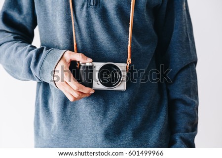 Photographer man with leather camera strap and mirrorless camera on white background Royalty-Free Stock Photo #601499966