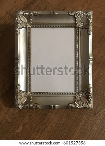 Vintage photo frame over wood background with empty white canvas, copy space available