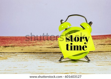  Conceptual image of Business Concept with words " story time" on at clock with a wooden desk background. Selective focus.