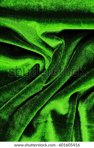 Extra green velvet close up photo. Velvet dress material cloth texture pattern. 
tailoring stitching concept. Shiny beautiful fashion fabric. Shiny clothing material sample.Creased fabric.