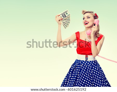Woman with money, talking on phone, dressed in pin-up style, on green background. Caucasian model posing in retro fashion and vintage concept. Copyspace area for advertising slogan or text message.