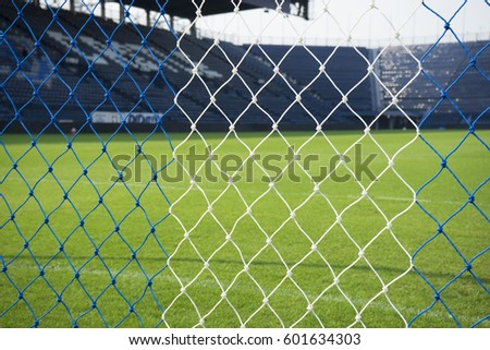 Close up of net soccer goal with blurred grass field background