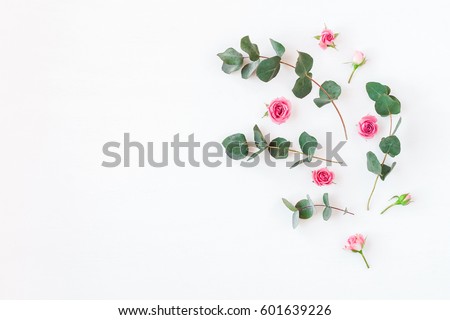 Flowers composition. Rose flowers and eucalyptus branches on white background. Flat lay, top view, copy space. Royalty-Free Stock Photo #601639226
