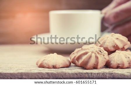 Cup of coffee with biscuit cookies and newspapper. Chocolate biscuit cookies. Chocolate cookies on white linen napkin on wooden table. Coffee break , breakfast.selective focus.vintage tone