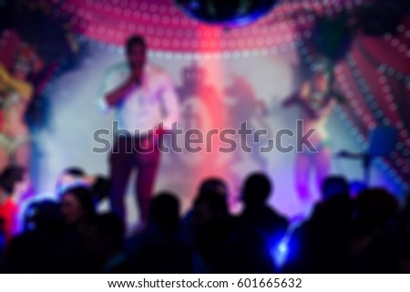 a lot of people at floor having fun and dancing listening a music in stage lights put hands up