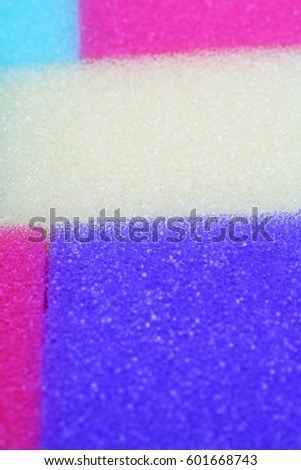 
Cleaning kitchen sponge texture as background. Colorful yellow pink green purple blue multicolor sponges. Close up macro about sponges. Sponge pattern textures concept background or wallpaper 

