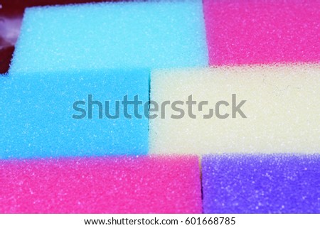 
Cleaning kitchen sponge texture as background. Colorful yellow pink green purple blue multicolor sponges. Close up macro about sponges. Sponge pattern textures concept background or wallpaper 

