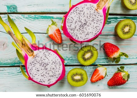 Dragon fruit, pitaja and other fruits on wooden background.