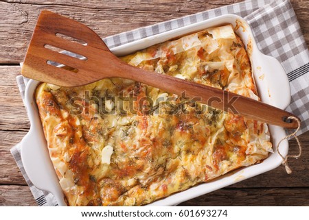 Balkan food: Serbian pie Gibanica with cheese, eggs and greens close-up in a baking dish. horizontal view from above
