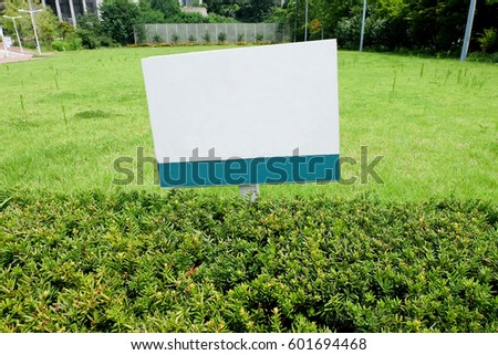 white signboard on grass field