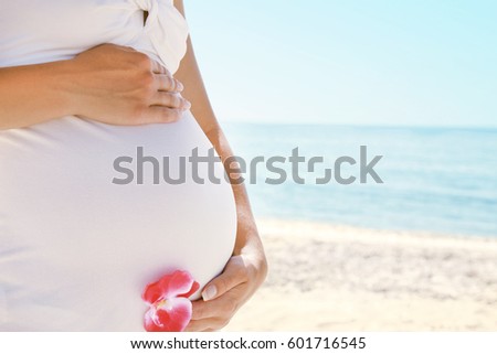 Happy beautiful pregnant woman on the sea in the summer on the nature