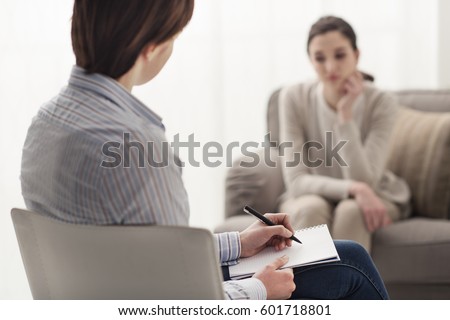 Psychologist listening to her patient and writing down notes, mental health and counseling concept Royalty-Free Stock Photo #601718801