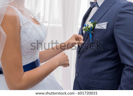 The bride wears a boutonnier to the groom