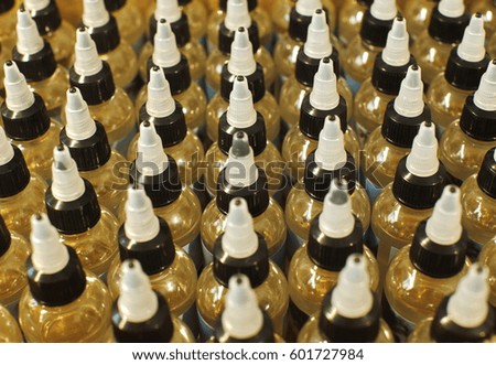 Many plastic bottles with caps with liquid for electronic cigarettes top view close up