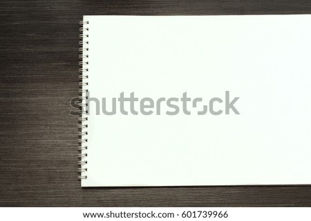 Blank open notepad for sketching  on wooden table.