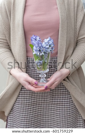 girl holding a glass of hyacinths