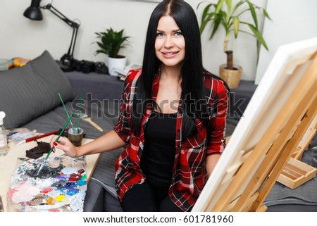 Young woman drawing on canvas