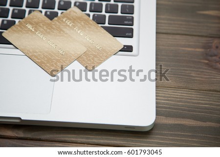 Two gold credit cards on laptop keyboard