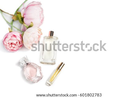 Perfume bottles with flowers on light background. Perfumery, cosmetics, fragrance collection. Free space for text. Royalty-Free Stock Photo #601802783