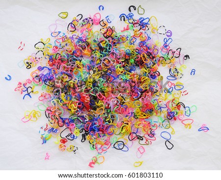 Colored abstract background. Clip for weaving. A scattering of colorful small rubber bands. Weaving bracelets out of rubber bands.