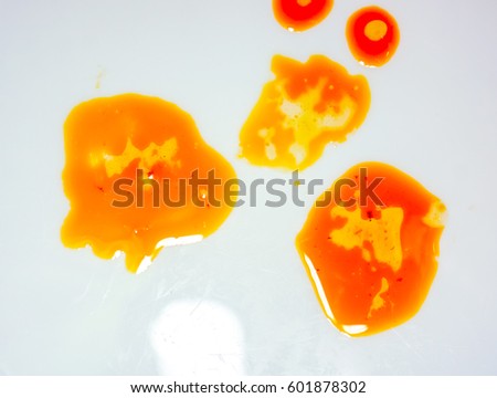 white plate with chaotic big bright oil spots with air bubbles. colorful orange golden yellow different sizes oil with light circles inside every one. abstract picture made of food oil