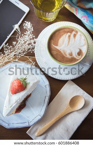 coffee cup and delicious cake strawberry and relax time mobile on table in coffee shop