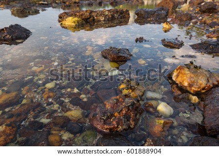 Beautiful nature, tropical beach with clear water and stones. reflection and cloudy blue sky background