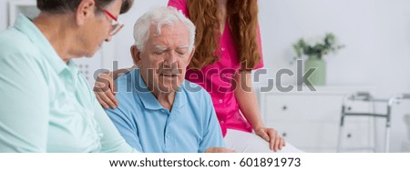 Two thoughtful senior citizens with a nurse
