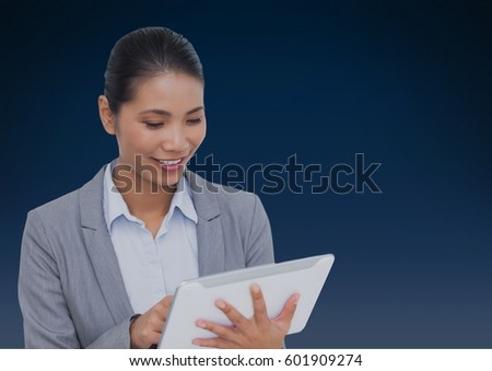 Digital composite of Businesswoman using tablet against a dark blue background