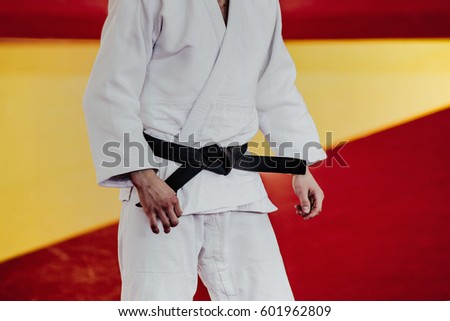 closeup man athlete judoka in white kimono and black belt