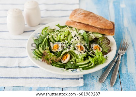 Quail Egg Salad with Mixed Salad Leaves, Cucumber, Curry Yogurt Dressing and Black Sesame Seeds, copy space for your text