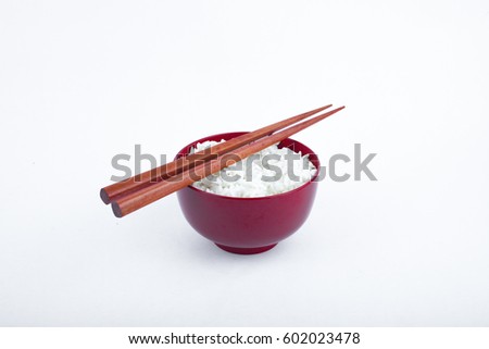 Bowl of rice and chopsticks isolated on white background with selective focus