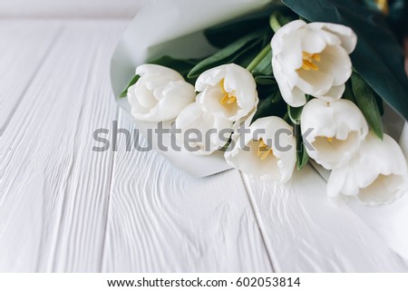 Mother's Day . white tulips on white wooden background