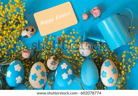 Happy Easter greeting card. Easter painted eggs and flowers on blue background